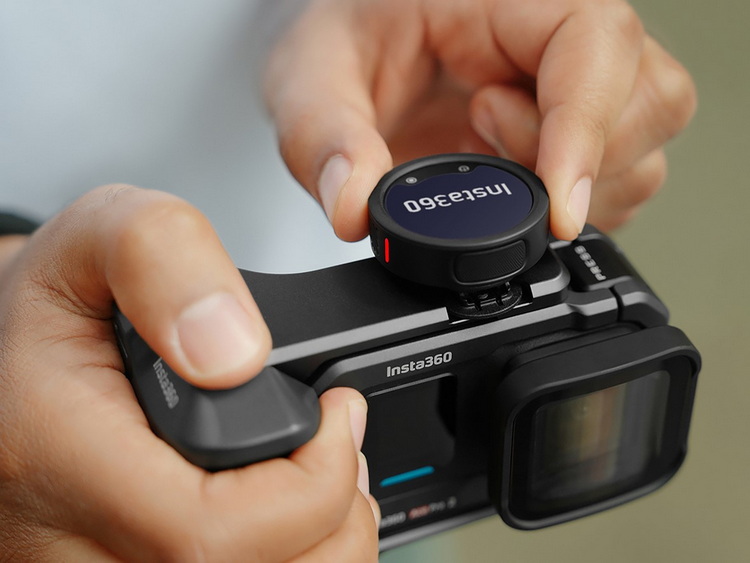 an_insta360_mic_pro_its_on_top_of_a_insta360camera_while_hands_adjust_it.jpeg